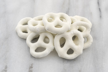 A small pile of yogurt pretzels on a gray marble cutting board.