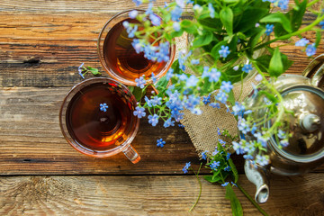Romantic background with cup of tea ,lilac flowers and open book over white table