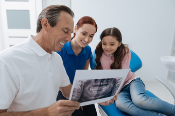 Delighted mother and daughter watching picture of the jaw