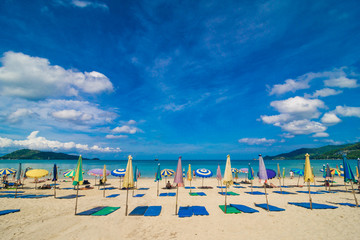 Obraz premium Chairs And Umbrella In Palm Sand Beach