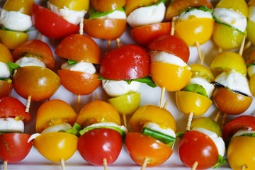Mini skewers with fresh tomatoes, mozzarella cheese and basil