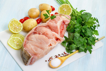 Raw Catfish with herbs and spices on table