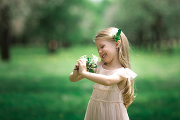 Little girl is walking in an apple garden