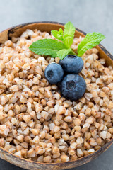 Buckwheat porridge in a bowl with mint leaves and blueberries.