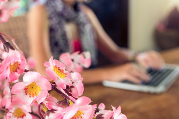 Obraz na płótnie Canvas Attractive female university student using laptop on a wooden table.