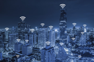 Wifi network connection concept on blue tone aerial view of cityscape business district at twilight background.
