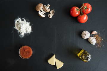 top view of ingredients for preparing italian pizza on dark surface