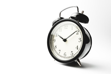 black vintage alarm clock isolated on white background show time at ten minutes past ten o'clock