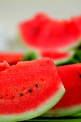 Fresh ripe watermelon slices with black seeds close up.