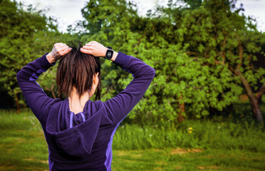 Obraz premium The girl is preparing for a training session in the park. Workout outdoors. Healthy lifestyle