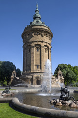 Fototapeta na wymiar Germany, Baden-Wuerttemberg, Mannheim, near Planken: Water Tower on Friedrichsplatz square with fountain and blue sky in the background