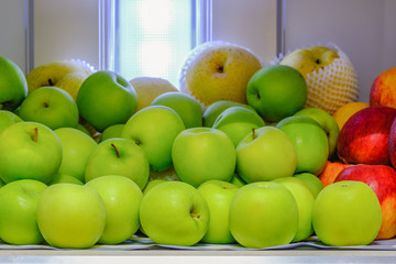 many green apples in refrigerator with red apples and pear