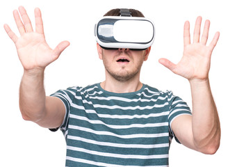 Naklejka premium Amazed man wearing virtual reality goggles watching movies or playing video games, isolated on white background. Surprised male in VR glasses. People experiencing 3D technology.