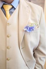 buttonhole flower on groom's wedding coat. detail of groom's wedding dressup