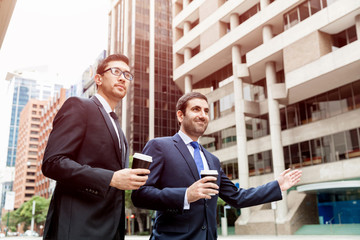 Two young businessmen hailing for a taxi