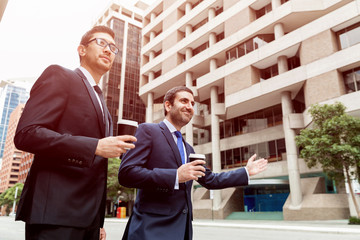 Two young businessmen hailing for a taxi