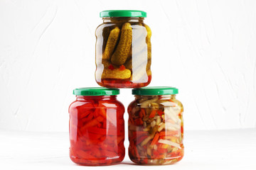 Jar with variety of pickled vegetables. Carrots, field garlic, cucumber in glas. Preserved food