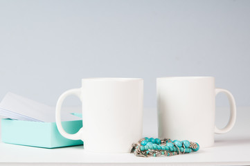 Obraz na płótnie Canvas mockup of two white coffee mugs in a simple setting