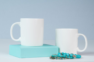 mockup of two white coffee mugs in a simple setting