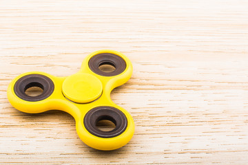 Fidget finger spinner stress anxiety relief toy isolated on wooden background.