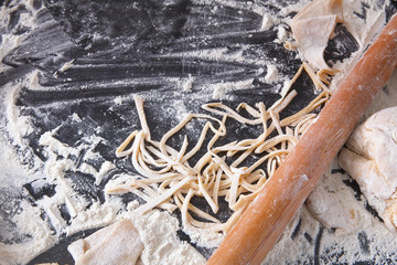 Cooking noodles concept on black background, sprinkled flour with copy space