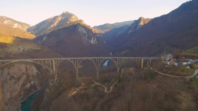 Panorama of concrete arched bridge across the river and mountain in spring
