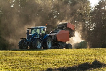 Blue tractor on the pasture.. Agricultural work on the farm in the Czech Republic.