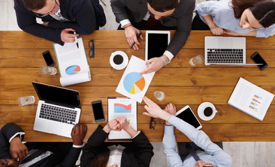 Group of busy business people meeting in office, top view