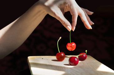 Female hand selecting a cherry