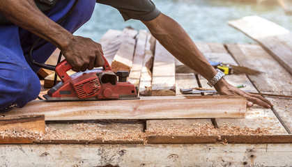 Worker trimming the tree with a professional chainsaw