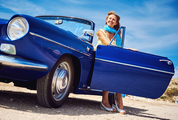 Beautiful woman sitting in retro cabriolet car