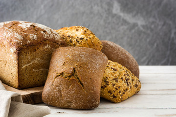 Mixed bread on white wooden background.Copyspace
