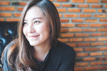Closeup portrait image of beautiful Asian woman with smiley face and feeling good in loft cafe