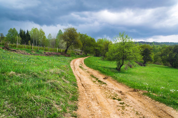 Mountain village road with cloudy sky