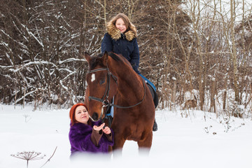 Fototapeta premium Teenager girl, mom and horse in a winter