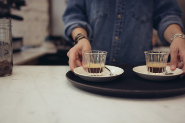 Mid section of a woman holding a tray of coffee cups at restaurant