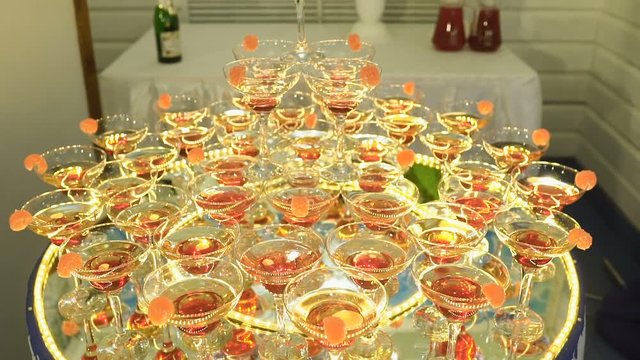 A beautiful pyramid of glasses with champagne and pieces of fruit in it