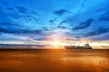 Cargo Ship in the Sea with Beautiful Twilight Sunset Sky in Summer (Complementary Color Blue - Orange)