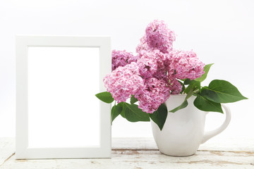 Bunch lilac in vase on wooden table and white frame mock up