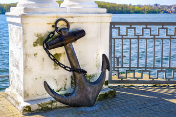 Vintage rusty anchor in the park near lake
