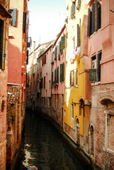 Fototapeta na wymiar Old buildings line up a canal in Venice Italy on a warm spring day