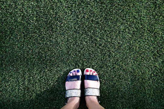Female feet on green grass in the park