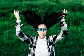 Positive pretty girl outdoor showing tongue and throw her hair