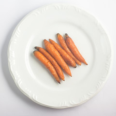 Cooked organic carrots over a plate