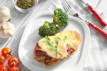 Tasty chicken parmesan with broccoli on plate