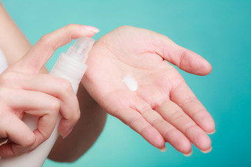 Woman putting white cream on hand