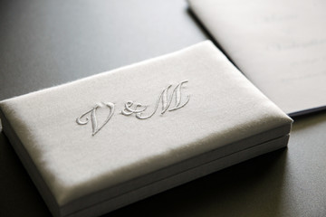 scatoletta in tessuto con scritto sopra le lettere D & M su tavolo lucido scuso