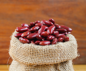Red bean or red kidney bean in hemp sack on wooden background. red beans are beneficial support heart health, cholesterol-free source of high-quality plant protein beans.