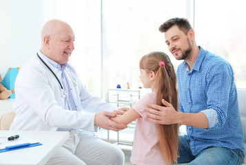 Obraz premium Little girl with father at doctor's office