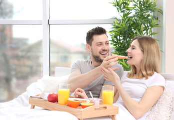 Couple having breakfast in bed